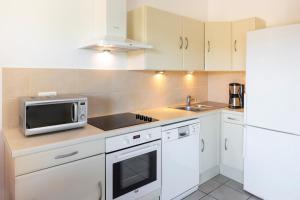 a white kitchen with a microwave and a sink at Casa Mia in Porto-Vecchio +21 photos