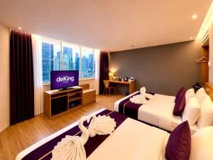 a hotel room with two beds and a flat screen tv at deKing Hotel Twin Towers by DK Hospitality in Kuala Lumpur
