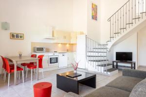 a living room with a couch and a table and a kitchen at Casa Mia in Porto-Vecchio