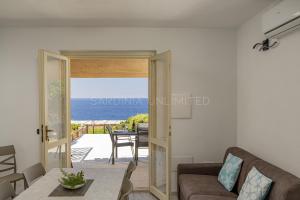 a living room with a view of the ocean at Villetta Luce Marina in Costa Paradiso +28 photos
