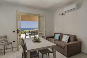 a living room with a couch and a table at Villetta Luce Marina in Costa Paradiso