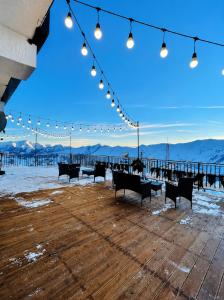 a group of benches sitting on a pier with lights at winter house GUDAURI in Gudauri