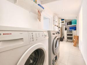 a laundry room with a washer and dryer at '24 Gordonia', Spacious Condo - Sleeps 7, Sea Front, Easy Beach access in Gordonʼs Bay