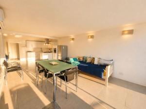 a living room with a table and a couch at '24 Gordonia', Spacious Condo - Sleeps 7, Sea Front, Easy Beach access in Gordonʼs Bay