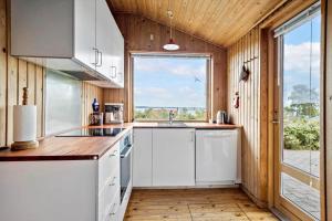 a kitchen with white cabinets and a large window at FY269-Faaborg-Lille-Stege-2 in Faaborg +18 photos