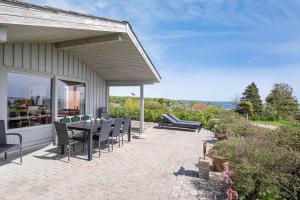 a patio with a table and chairs and the ocean at FY269-Faaborg-Lille-Stege-2 in Faaborg
