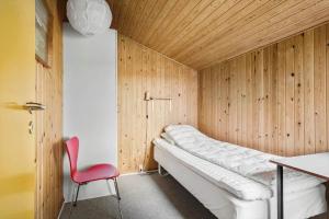 a bedroom with a bed and a red chair at FY269-Faaborg-Lille-Stege-2 in Faaborg