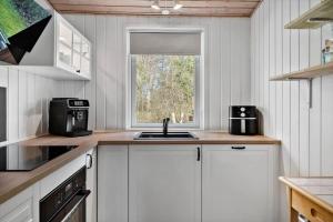 a kitchen with white cabinets and a sink and a window at LF10316-Hurup-Thy-Vagtelvej-16 in Sønder Ydby
