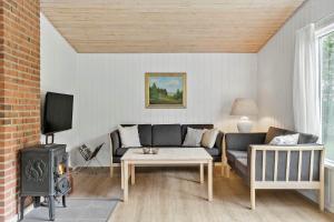 a living room with a couch and a stove at LF10316-Hurup-Thy-Vagtelvej-16 in Sønder Ydby