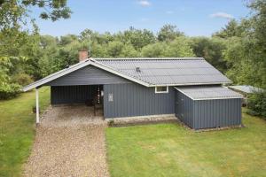 a gray building with a garage in a yard at LF10316-Hurup-Thy-Vagtelvej-16 in Sønder Ydby