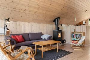 a living room with a couch and a fireplace at 8923-Allingabro-Poppelvej-17 in Allingåbro