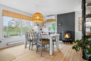 a dining room with a table and chairs and a fireplace at 30116-Odder-P-Baatrupsvej-47 in Odder