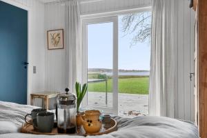 a bedroom with a bed with a table with cups and a window at 30116-Odder-P-Baatrupsvej-47 in Odder