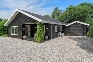 a black house with a gravel driveway at 30116-Odder-P-Baatrupsvej-47 in Odder