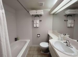 Ein weißes Badezimmer mit Badewanne, Toilette und Waschbecken in der Unterkunft Coast Capri Hotel in Kelowna