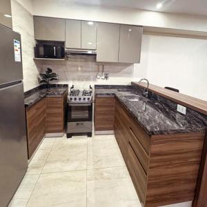 a kitchen with a stove and a sink in it at Depar 1 Dormitorio B in Cochabamba