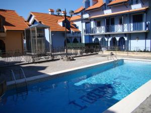 a swimming pool in front of a building at Apartamentos El Pinedo in Noja