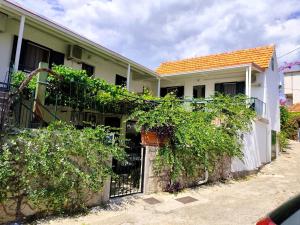a house with a fence and vines at Apartment Lore in Primošten