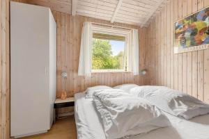 a bedroom with a bed with white sheets and a window at 588-N-Hundested-Krusemyntestien-5 in Hundested