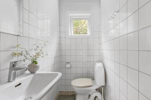 a white bathroom with a toilet and a sink at 588-N-Hundested-Krusemyntestien-5 in Hundested +11 photos