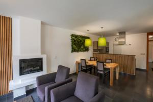 a dining room and living room with a table and chairs at Lipno Lake Resort in Lipno nad Vltavou