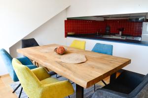 a wooden table with chairs and a kitchen in the background at Ferienwohnung NORA - direkt am Bodensee in Friedrichshafen
