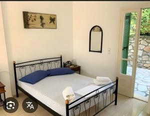 a bedroom with a bed with blue pillows and a mirror at Afales Villa and Studios in Exoyí