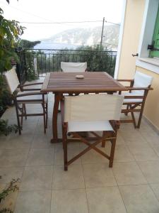 a wooden table and chairs on a balcony at Afales Villa and Studios in Exoyí