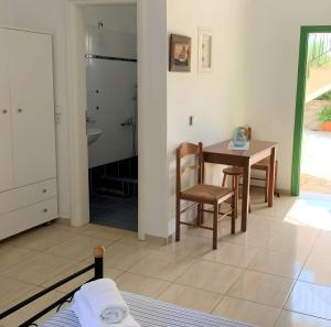 a room with a table and chairs and a bathroom at Afales Villa and Studios in Exoyí +74 photos