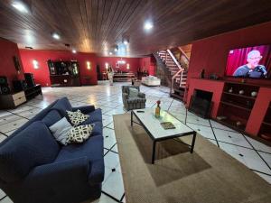 a living room with a blue couch and a tv at Casa de Araras in Araras Petropolis