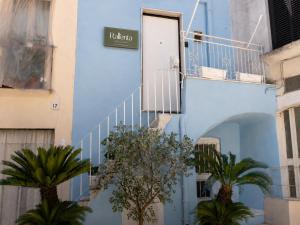 a blue building with a staircase and palm trees at Rallenta Casamassima in Casamassima