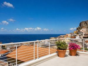 a balcony with flowers and the ocean in the background at Astra - Exclusive Rooms in Castelsardo