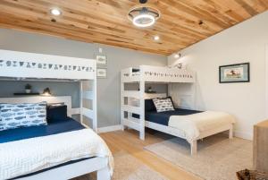 a bedroom with two bunk beds and a wooden ceiling at Bear on the Lake in Oakland