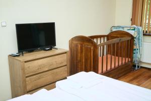 a bedroom with two cribs and a tv on a dresser at Guest House Fedor in Ribarica
