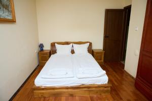 a bed with white sheets and pillows in a room at Guest House Fedor in Ribarica