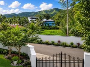 a fence in front of a house with a mountain in the background at Chooravelil Villa, Adimali - Family Stay Near Munnar in Anniyartholu