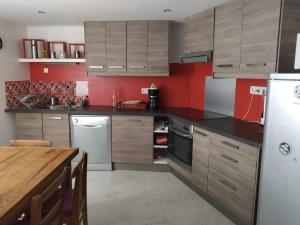 a kitchen with wooden cabinets and a white refrigerator at Village house 8 beds in Joncels