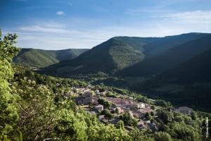 a small town in the middle of a valley with mountains at Village house 8 beds in Joncels