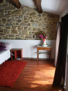 a room with a table and a stone wall at Village house 8 beds in Joncels
