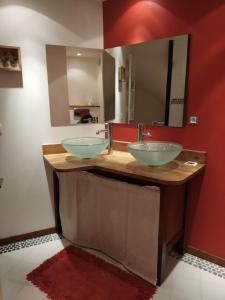 a bathroom with two sinks and a red wall at Village house 8 beds in Joncels +21 photos