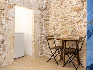 a table and two chairs next to a stone wall at Rallenta Casamassima in Casamassima