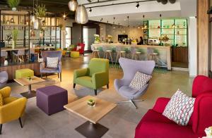 ein Restaurant mit bunten Stühlen und einer Bar in der Unterkunft Radisson Blu Hotel, Hasselt in Hasselt