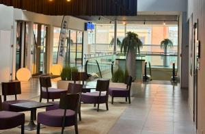 ein Restaurant mit lila Stühlen und Tischen in einem Gebäude in der Unterkunft Radisson Blu Hotel, Hasselt in Hasselt