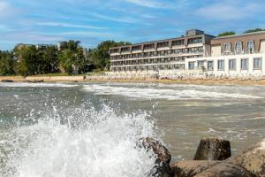 a body of water with a building in the background at HVD Nympha Hotel - All Inclusive, Private Beach & Free Parking - Adults Only in Golden Sands