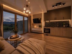 a living room with a couch and a table and a kitchen at Golden Trio Villas in Ząb