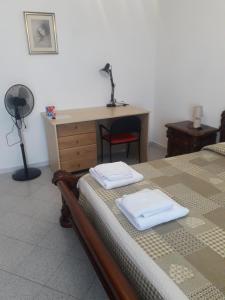 a bedroom with a desk and a bed with two towels at Doroteafarm, dove saltiamo sull'amore e i sogni in Scalea
