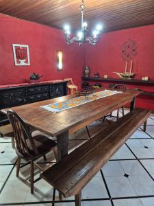 a dining room with a wooden table and a bench at Casa de Araras in Araras Petropolis