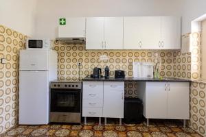 a kitchen with white cabinets and a white refrigerator at Casa de Jonathan in Vilarinho do Souto
