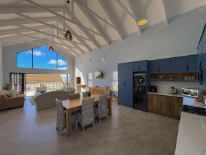 a kitchen and living room with a table and chairs at Swordfish Retreat in St. Helena Bay