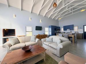 a living room with two couches and a table at Swordfish Retreat in St. Helena Bay